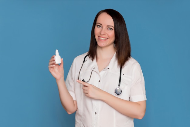 Happy doctor in white coat with a stethoscope holds medicine in his hands. Healthcare concept