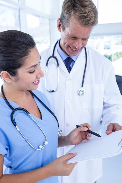 Happy doctors looking at clipboard