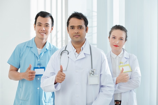 Happy doctors showing thumbs-up