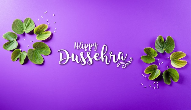 Happy Dussehra. Green leaf and rice on purple pastel background