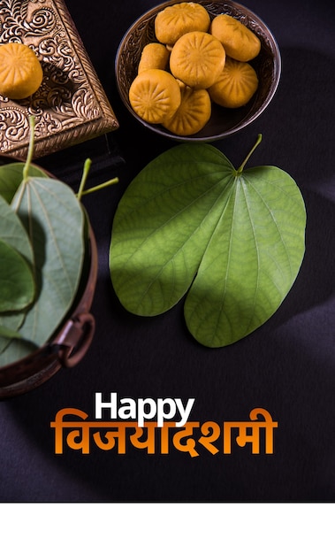 Photo happy dussehra or vijayadashami or ayudh puja greeting card using apta or bauhinia racemosa or bidi leaf and indian sweet pedha or pera