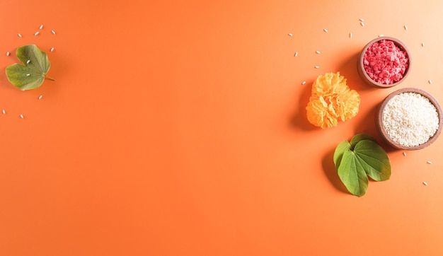 Happy Dussehra Yellow flowers green leaf and rice on orange background Dussehra Indian Festival concept