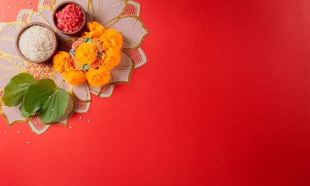 Photo happy dussehra yellow flowers green leaf and rice on red background