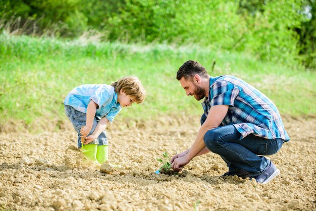 Happy Earth Day Family Tree Rich Natural Soil Eco Farm Small Boy Child Help Father In Farming New Life Ecological Engineering Father And Son Planting Flowers In Ground Earth Day