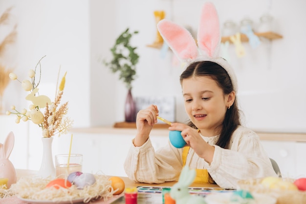 happy easter a beautiful child girl painting colorful eggs