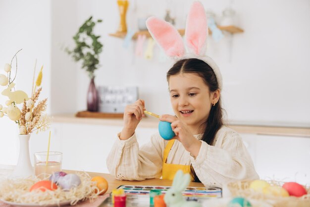 happy easter a beautiful child girl painting colorful eggs