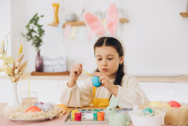 happy easter a beautiful child girl painting colorful eggs