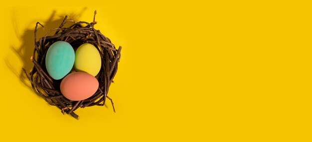 Happy Easter card colored pink easter eggs on a yellow nest background from above image