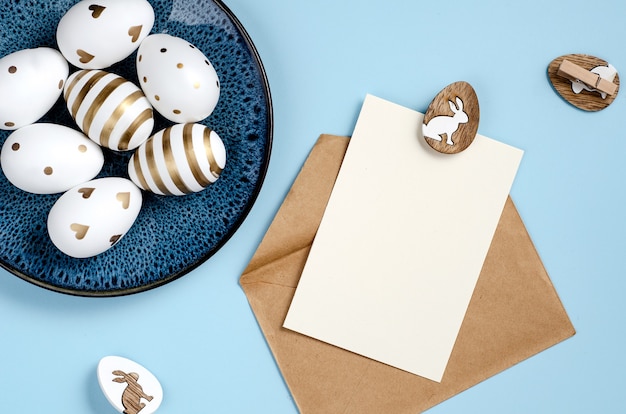 Foto mockup di carta di pasqua felice su sfondo blu con uova su un piatto blu scuro