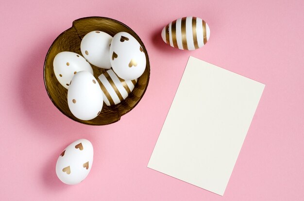 Foto mockup di carta di pasqua felice con le uova su sfondo rosa