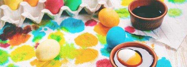 Foto celebrazione felice di pasqua, uova di pasqua dipinte su legno bianco