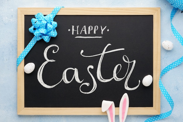 Photo happy easter chalkboard lettering with funny bunny ears and eggs