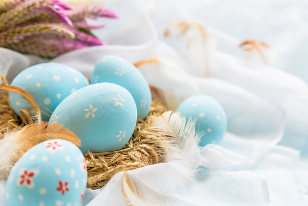 Happy easter! Colorful of Easter eggs with flower  on white cheesecloth background.