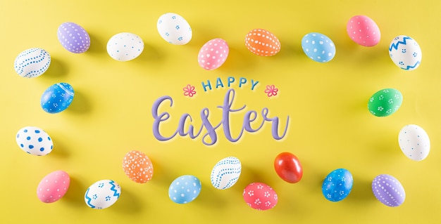 happy easter! colourful of easter eggs on pastel yellow