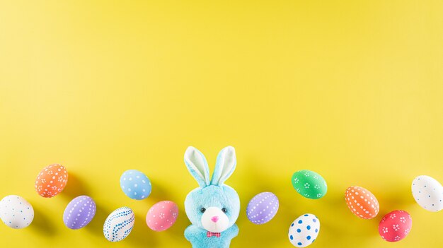 Happy easter! Colourful of Easter eggs on pastel yellow