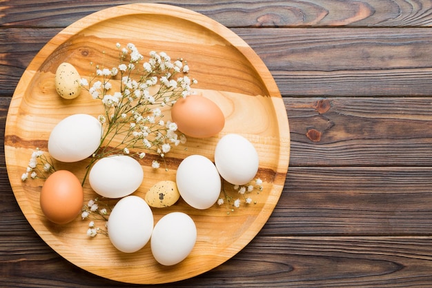 Photo happy easter composition easter eggs in basket on colored table with gypsophila natural dyed colorful eggs background top view with copy space