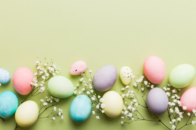 Happy Easter composition Easter eggs on colored table with gypsophila Natural dyed colorful eggs background top view with copy space