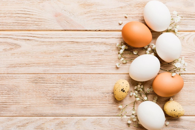 Happy Easter composition Easter eggs on colored table with gypsophila Natural dyed colorful eggs background top view with copy space