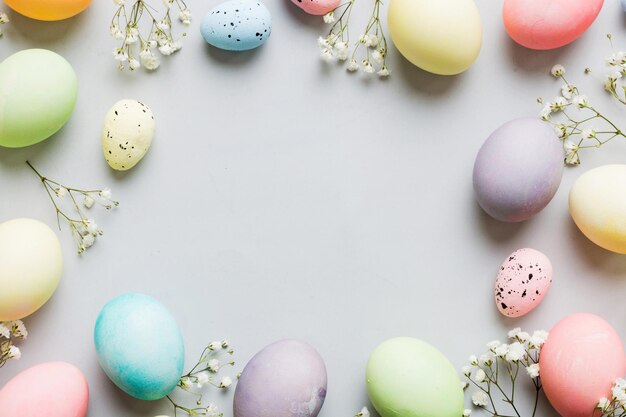 Photo happy easter composition easter eggs on colored table with gypsophila natural dyed colorful eggs background top view with copy space