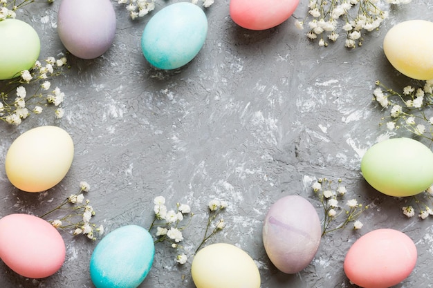 Happy Easter composition Easter eggs on colored table with gypsophila Natural dyed colorful eggs background top view with copy space