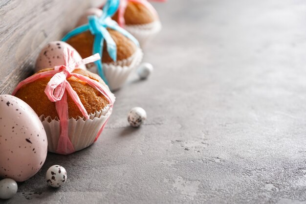 Foto buona pasqua concetto. uova di pasqua e cupcakes di pasqua su una superficie grigia, posto per il testo.