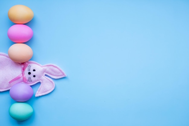 Концепция счастливой Пасхи Подготовка к празднику Пасхальные яйца и кролик изолированы на модном пастельно-голубом фоне простой минимализм плоский вид сверху копией пространства