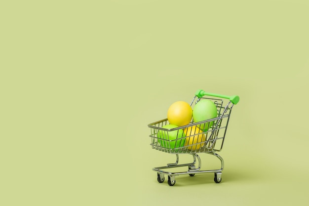 Фото Счастливая концепция пасхи с пасхальными яйцами в тележке супермаркета, магазинной тележке.
