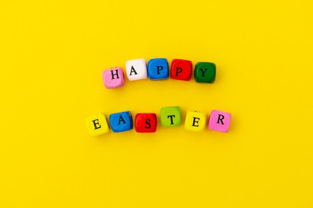 Happy easter. cubes with text on yellow background. ready greating card design for easter