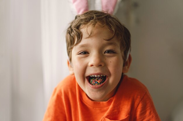 Happy Easter. Cute boy eats and plays with Easter sprinkles.