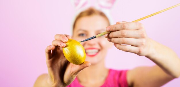 Happy easter day celebration smiling girl painting egg with paint brush eggs decorating ideas