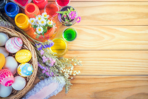 Happy Easter day colorful eggs and flower a set of food coloring, acrylic paintbrush for do it yourself on brown wooden floor with copy space