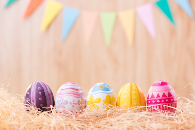 Happy Easter day colorful eggs on nest with blurred celebrate  party flags with copy space