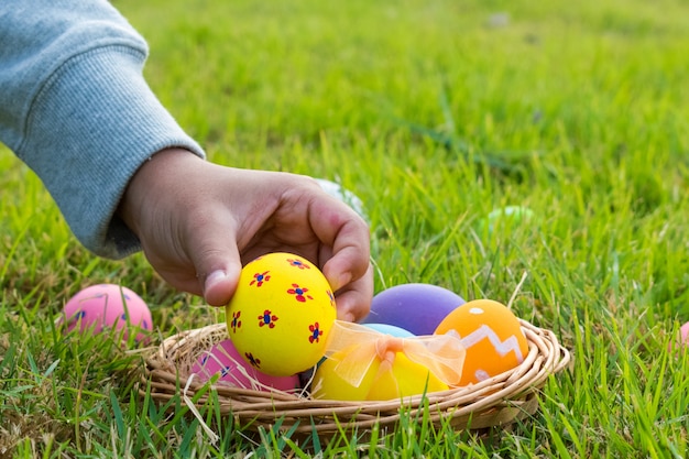 행복한 부활절 날. 부활절 달걀 개념입니다. 공원에서 다채로운 계란을 수집하는 소년.