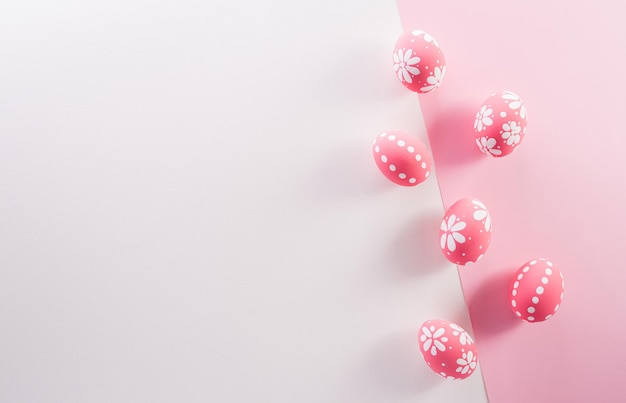 Концепция счастливого пасхального украшения Красочные пасхальные яйца на розовом и белом фоне