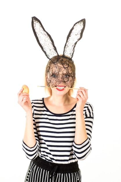 Photo happy easter easter day easter egg easter bunny woman holding painting brush in mouth decorating