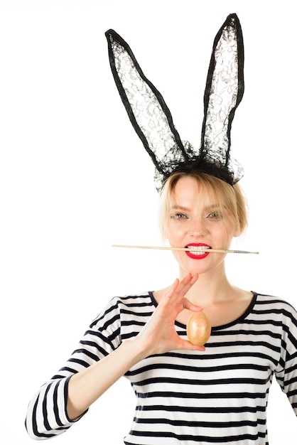 Foto buona pasqua giorno di pasqua uovo di pasqua coniglietto di pasqua donna che tiene il pennello in bocca decorare
