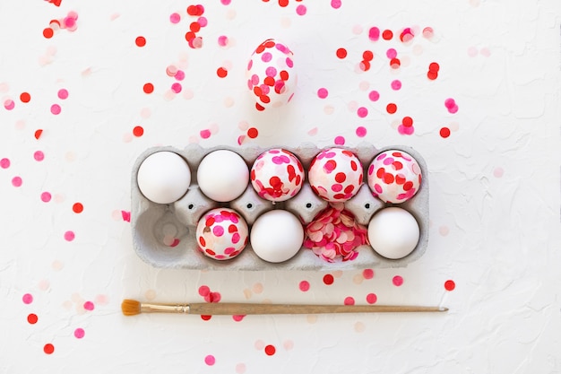 Happy Easter. Easter eggs decoration pink paper confetti.