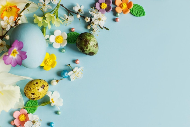 행복한 부활절 부활절 플랫은 세련된 계란과 파란색 배경 공간에 피어나는 봄 꽃으로 텍스트 현대 인사말 카드 또는 배너 자연적으로 칠해진 다채로운 계란과 꽃