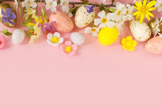 Happy Easter Easter flat lay with stylish eggs and blooming spring flowers on pink background