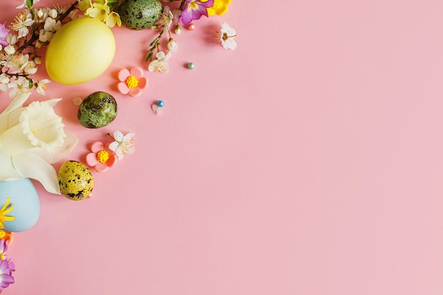 Happy easter easter stylish eggs and blooming spring flowers on pink background space for text modern greeting card or banner natural painted colorful eggs and blossom easter still life