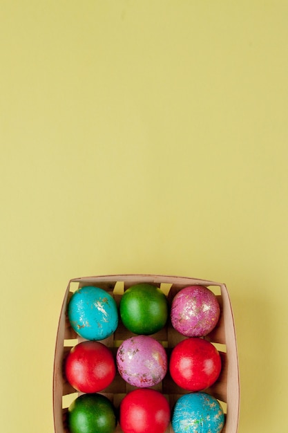 Happy Easter eggs yellow background. Golden shine decorated eggs in basket, for greeting card, promotion, poster. Copy space