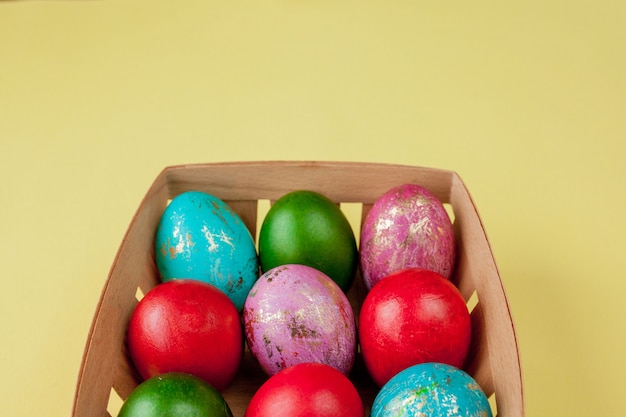 ハッピーイースターの卵の黄色の背景。黄金の輝きは、グリーティングカード、プロモーション、ポスター用のバスケットに卵を飾っています。コピースペース