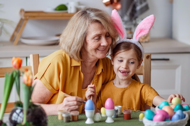 Foto buona pasqua famiglia anziana nonna e nipotina con orecchie di coniglio