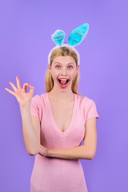 Buona pasqua! la ragazza mostra il segno bene. pasqua. coniglietto. vacanze di primavera. pasqua. ragazza sorridente con orecchie da coniglio. orecchie da coniglio. vendita. sconto. firma bene. ok. va bene.