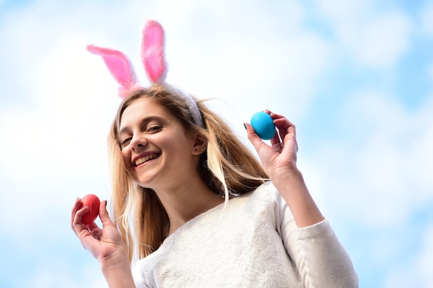 Счастливой пасхи девочка с кроличьими ушками, яйца на голубом небе