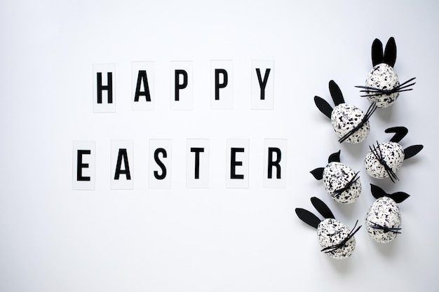 Happy Easter greeting card with funny Easter eggs decorated as spotted black and white bunnies