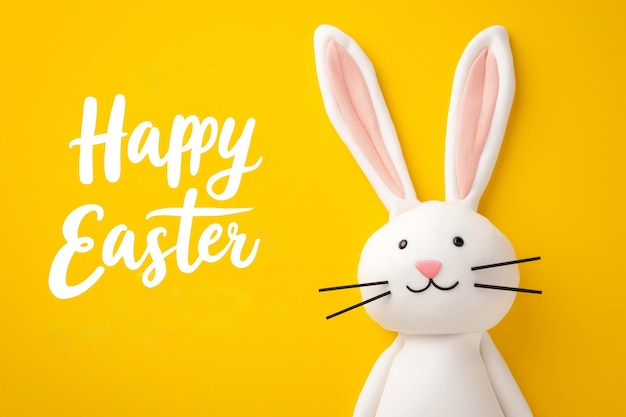 Photo happy easter happy easter greeting with cartoon bunny on bright yellow background