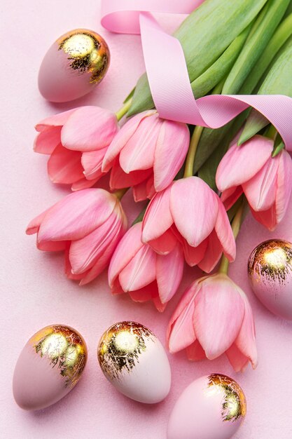 Happy easter holiday greeting card bouquet of pink tulips and easter egg on pink background space for text