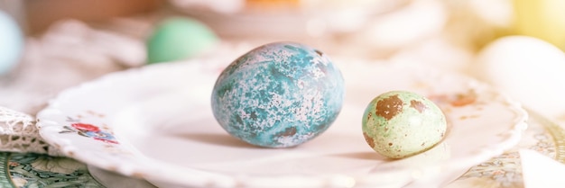 Foto buone vacanze di pasqua in primavera dipinte di verde smeraldo uova colorate in ciotola e piatto sul tavolo festivo decorazioni per la casa cibo tradizionale sofisticato paese rustico stile tavolo bagliore banner