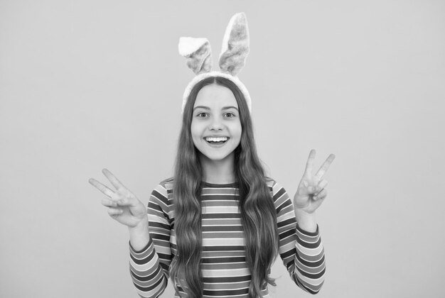 Happy easter kid girl in rabbit bunny ears smiling on holiday easter bunny